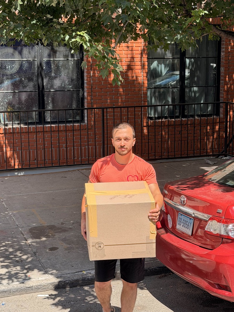 Lovely Moving & Storage crew carrying a wrapped item during a move